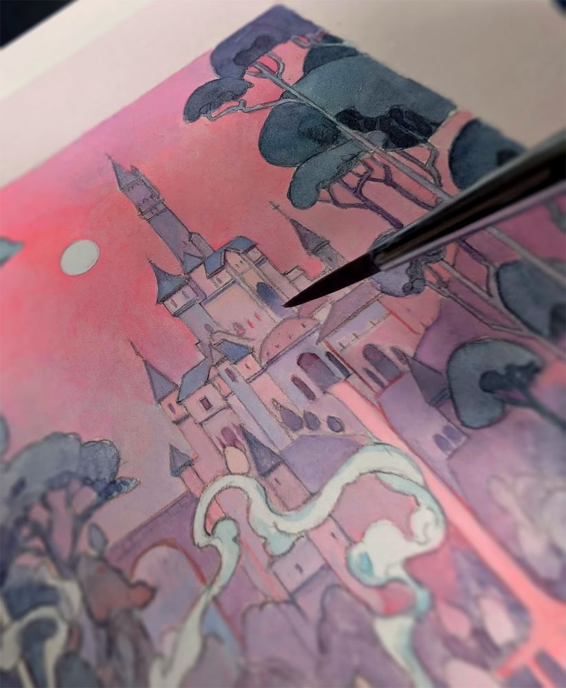 Close up photograph of a paintbrush hovering over a traditional painting of a fairy tale looking castle in pink and purple tones. The image does not show the entire painting and smoke can be seen in the lower left of the image, suggesting further details to be revealed. 