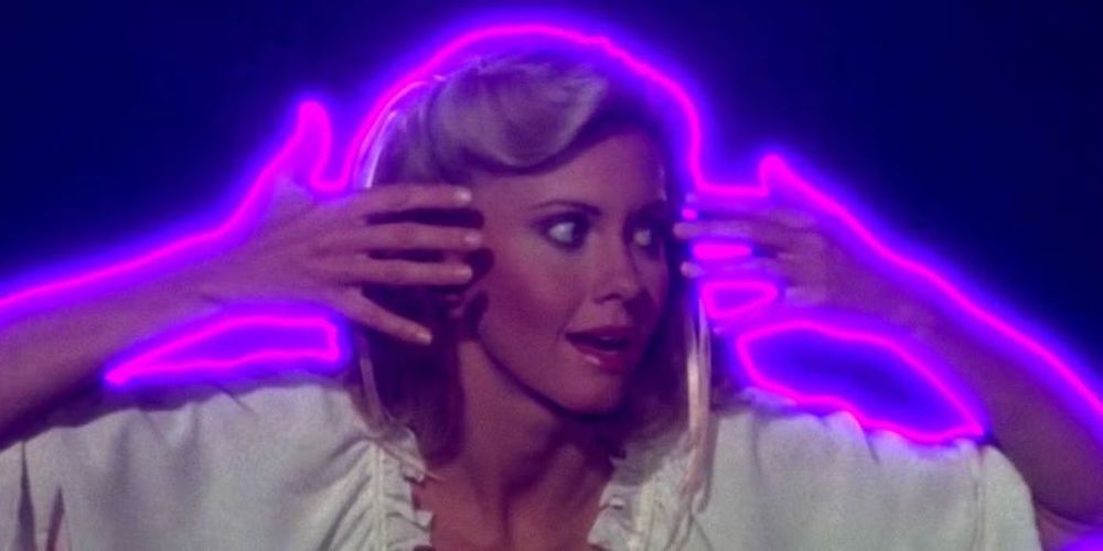 Olivia Newton John outlined in electric purple light AS SHE SHOULD BE