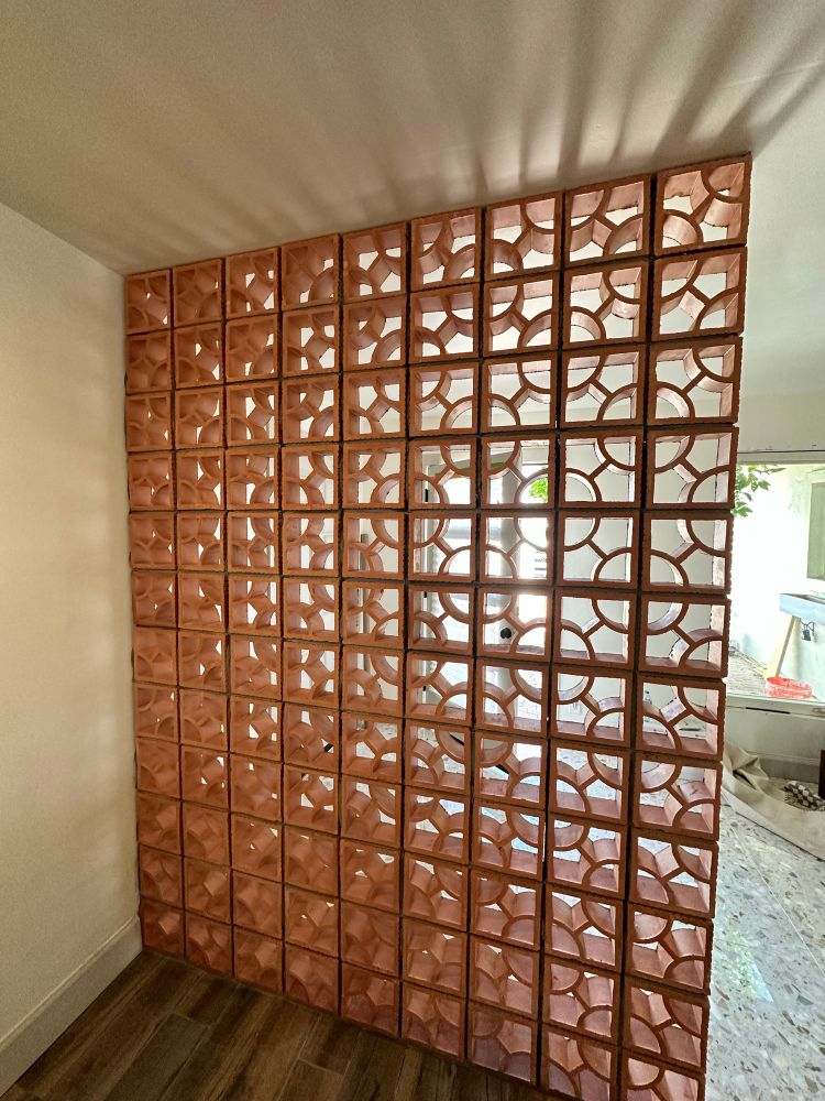 A breeze block wall with light coming through from behind. 