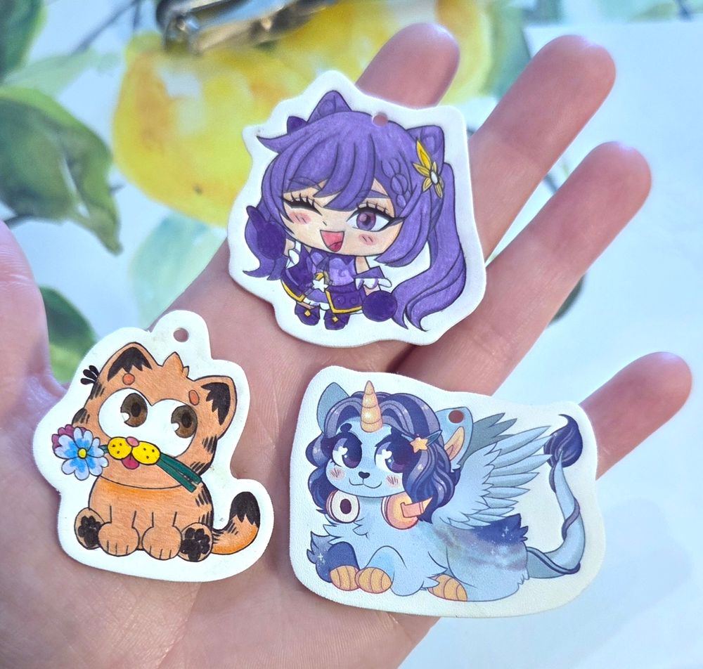 Handmade shrinky dinks of Garfield, Keqing from Genshin Impact, and my unicorn cat OC.