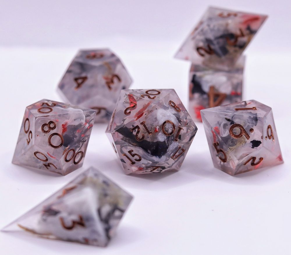 7 ttrpg dice. They are white with white swirls. Black moss, grey moss, red foil and black foil are poking through the misty look of it. They are inked in copper.
