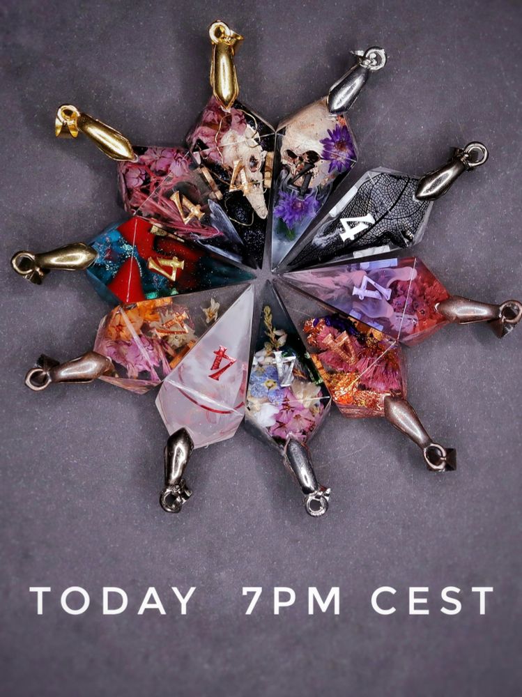 10 different colorful D4 Pendants laying in a circle pointing inward. Below them is the text Today 7pm CEST.