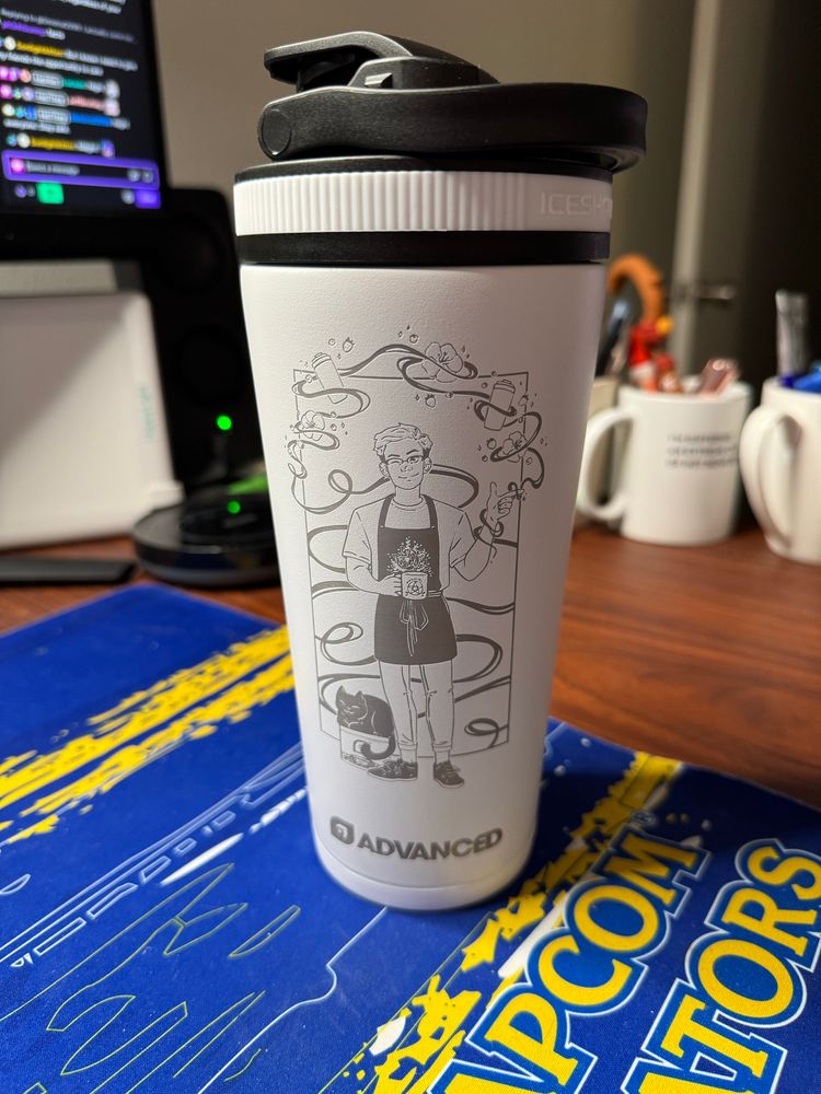 My custom ice shaker, which is a white shaker with a custom design, showing me magically levitating ice shakers, hibiscus flowers, and berries, while holding a pentagram coffee mug, with my cat sitting on a jar of AdvancedGG 