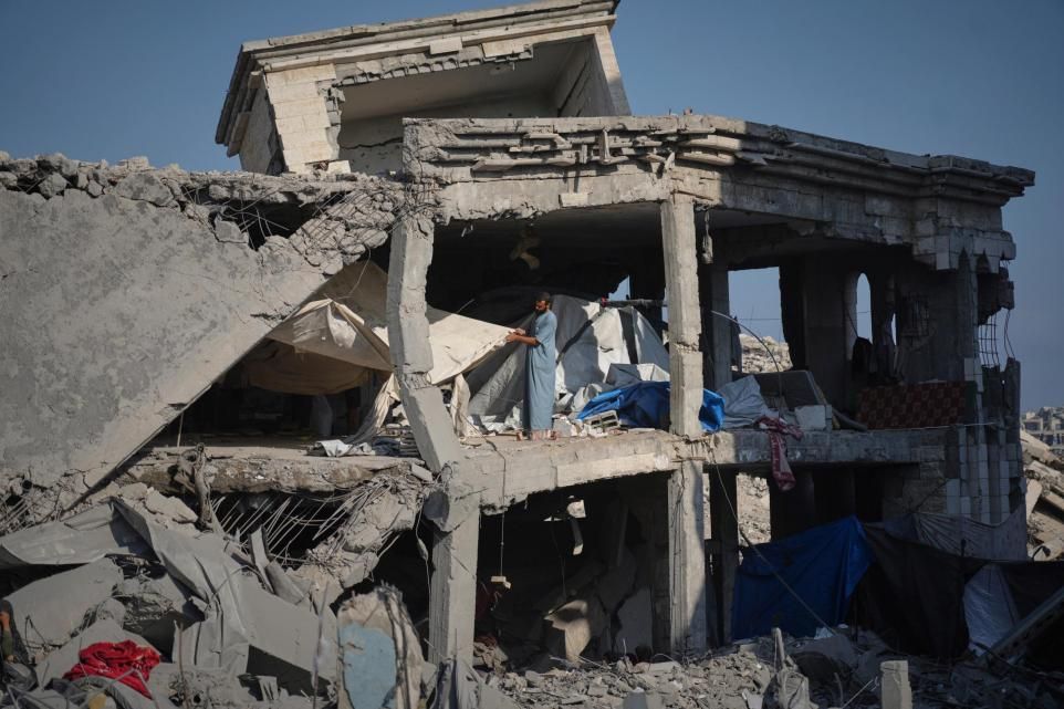 People inspecting the damage at the Sheikh Radwan al-Taba UNRWA clinic following an Israeli army bombardment in Gaza City (Jehad Alshrafi/AP)