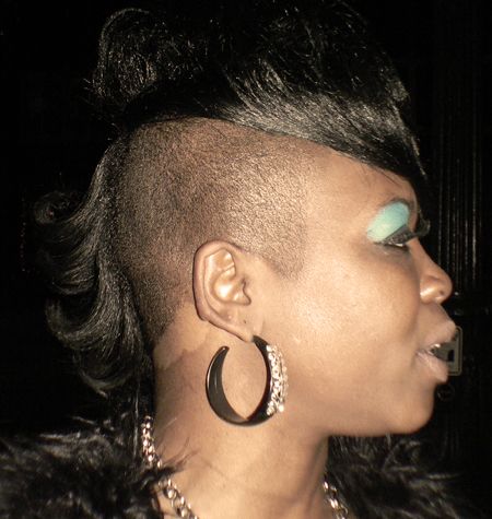 Side of persons head with shaved sides and a permed artistic Mohawk 