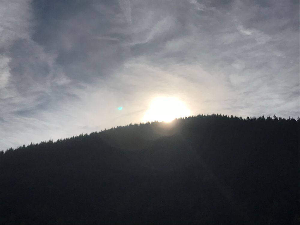 Rising sun and silhouette of a hill