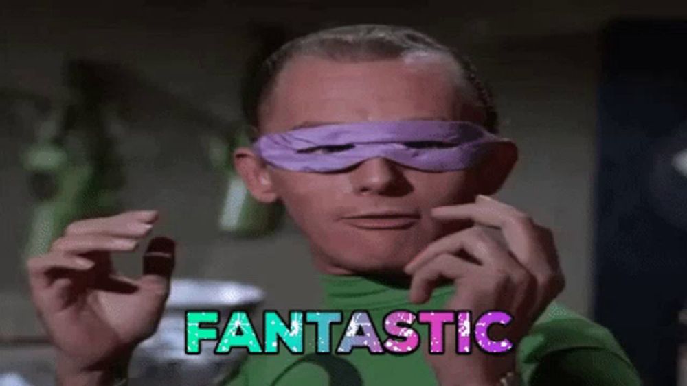 a man in a green shirt is wearing a purple mask that says fantastic on it