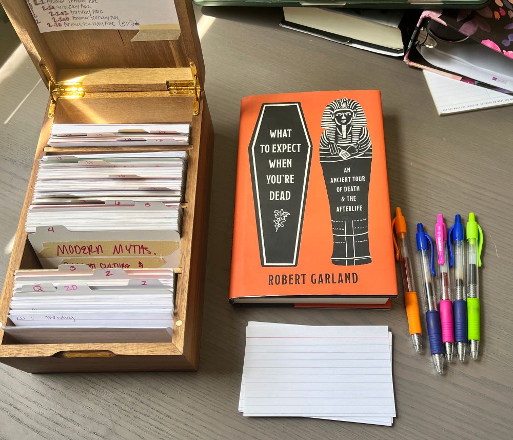 My Zettelkasten slip box, index cards, pens and my copy of What to Expect When You’re Dead by Robert Garland