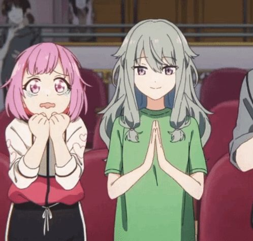 a girl with pink hair and a girl with grey hair are standing next to each other with their hands folded