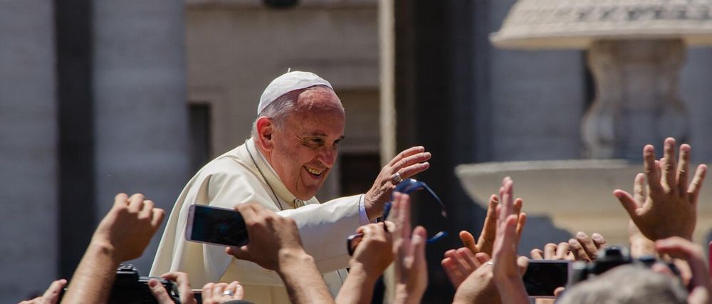 The late Pope Francis waving at congregation