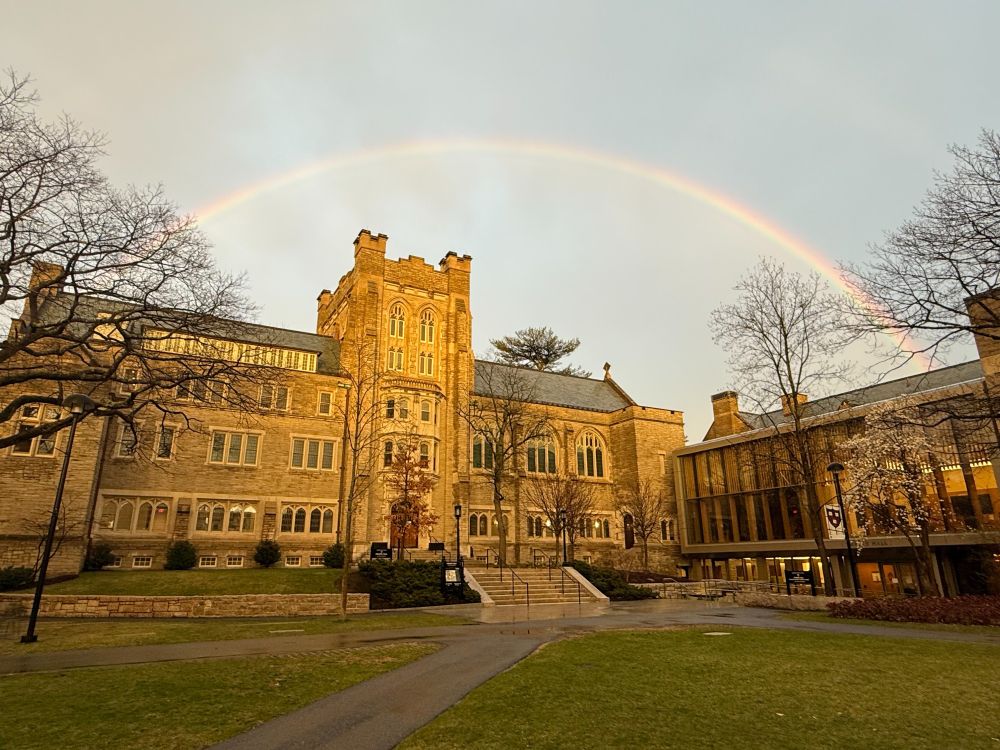 Swartz Hall during golden hour with a rainbow in sky