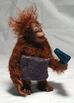 Figur eines Orang-Utans mit zerzaustem Fell, der ein graues Handtuch um die Hüfte trägt und einen blauen Haartrockner hält.