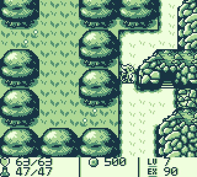 A screenshot of a Game Boy RPG. The player character is near a forested area, look onward towards a cave entrance.
