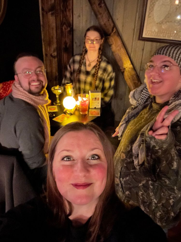 Four people seated at a table smile at the camera. 