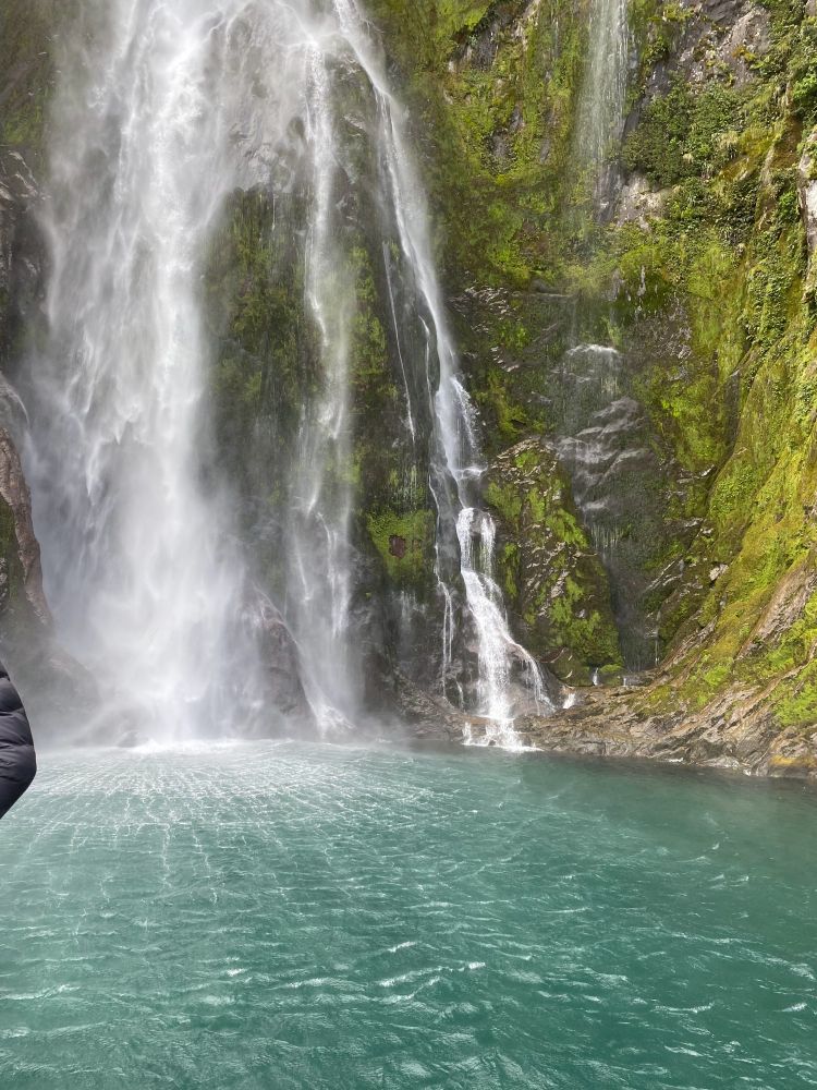 A gigantic multi streamed almost sheer vertical waterfall spilling into concentric rings and radiating shock waves into ridiculously clear turquoise water. 
