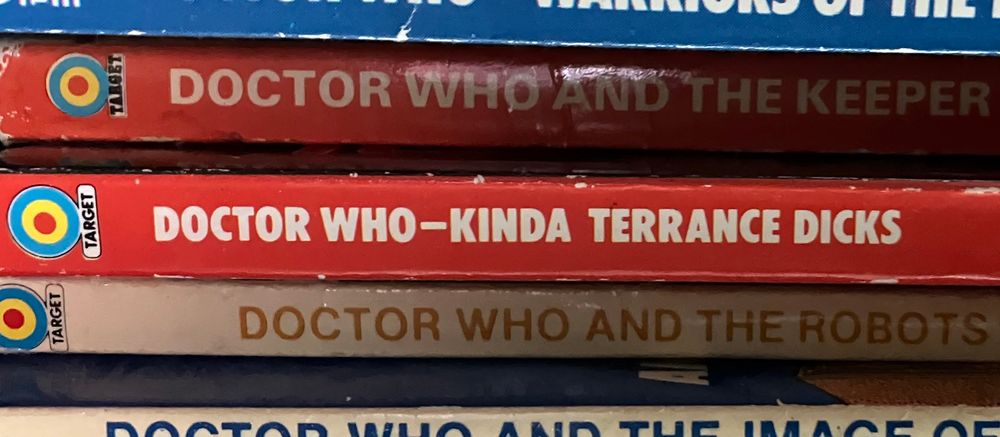 A stack of Doctor Who novels. The centre one reads DOCTOR WHO — KINDA TERRANCE DICKS. 