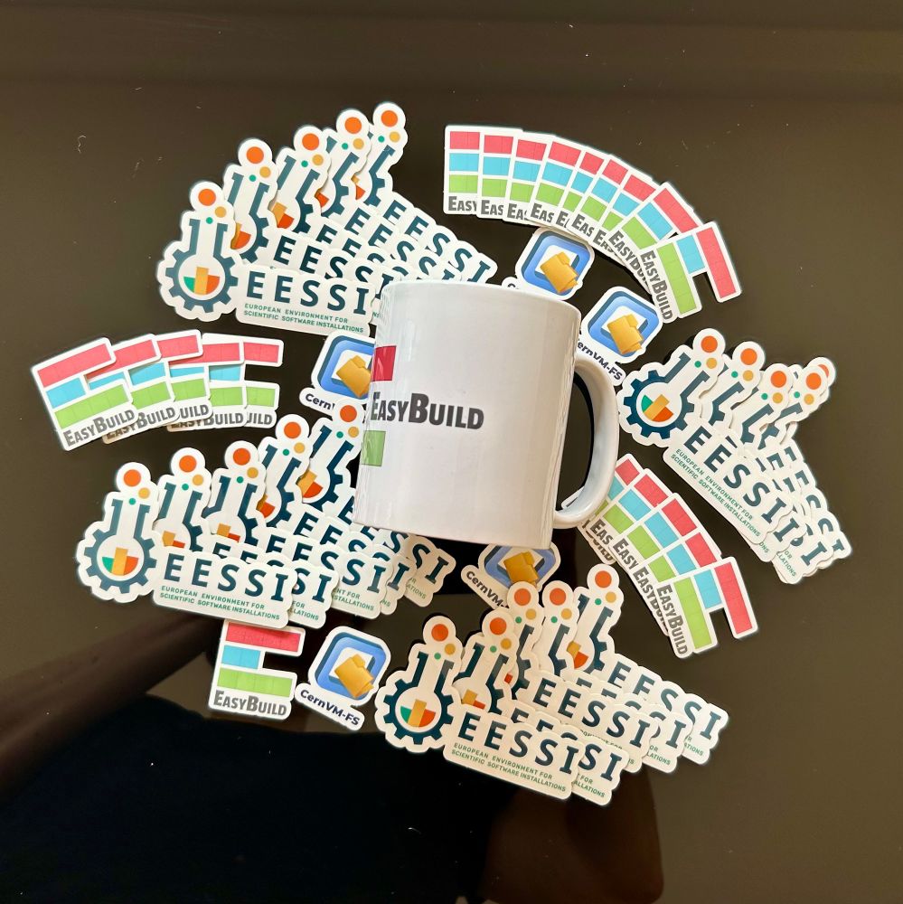 EasyBuild mug on top of EESSI, EasyBuild, and CernVM-FS stickers