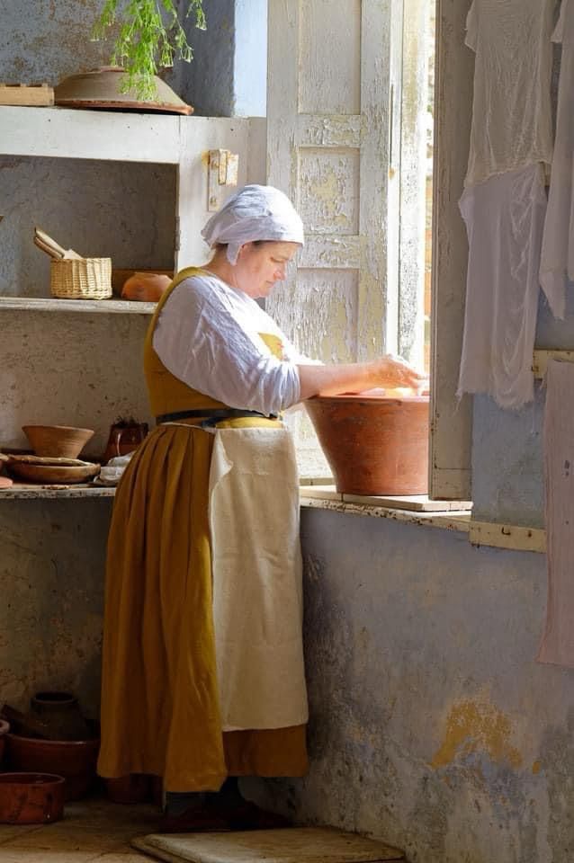 Tudor dairymaid hand churning  butter