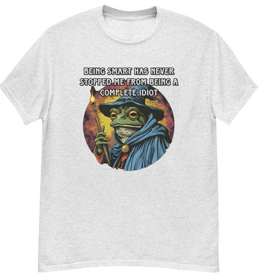 image d'un t shirt portant une illustration d'un crapaud mage, portant un chapeau et une robe à capuche bleue, et un baton. Acollé à l'image le texte dit en substance : "être intelligent ne m'a jamais empêché d'être un complet abruti".
(en vo : "Being smart has never stopped me from being a compelte idiot")