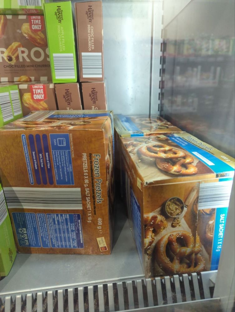 A view inside a freezer at Aldi showing three boxes of frozen bake-at-home pretzels