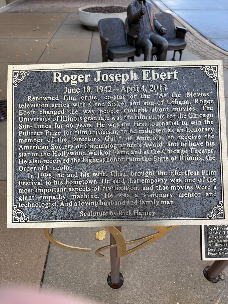 Roger Joseph Ebert
June 18, 1942 - April 4, 2013
Renowned film critic, co-star of the At the Movies" television series with Gene Siskel and son of Urbana, Roger Bbert changed the way people thought about movies.
The
University of Illinois graduate was the film critic for the Chicago Sun-Times for 46 years. He was the first journalist to win the Pulitzer Prize for film criticism, to be inducted as an honorary member of the Director's Guild of America to receive the American Society of Cinematographer's Award, and to have his star on the Hollywood Walk of Fame and at the Chicago Theater, He also received the highest honor from the State of Illinois, the Order of Lincoln
In 1998, he and his wife, Chaz, brought the Ebertfest Film Festival to his hometown. He said that empathy was one of the most important aspects of civilization, and that movies were a glant empathy machine. he was a visionary mentor and technologist And a loving husband and tamily man,
Sculpture by Rick Harney
Joy & Habeel
Joan & G. T.!
Betsy Hendr Intertraterni ofillinois a Loretta & W Peggy & Pau