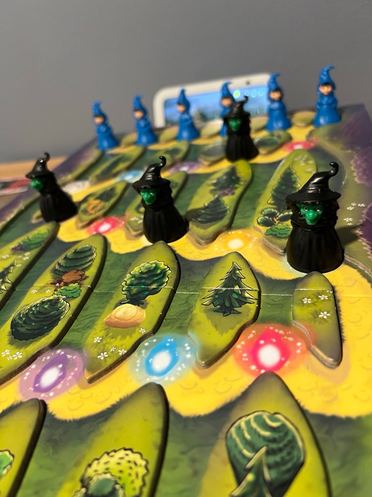 Students and witches lined up on a path prepared in boardgame Magic Mountain