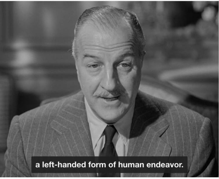 Black and white screenshot of a well dressed, middle aged man. Caption: a left-handed form of human endeavor.