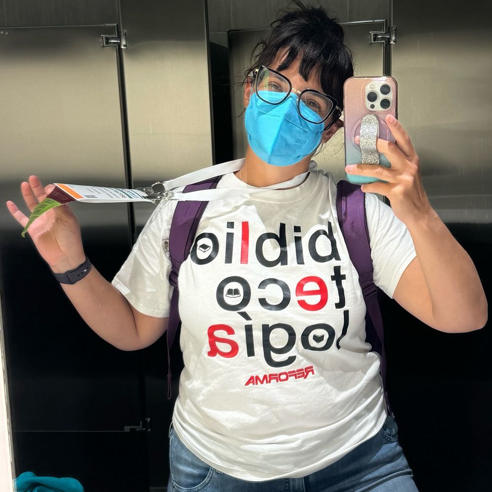 Latina librarian wearing KN95 mask taking a bathroom mirror pic
