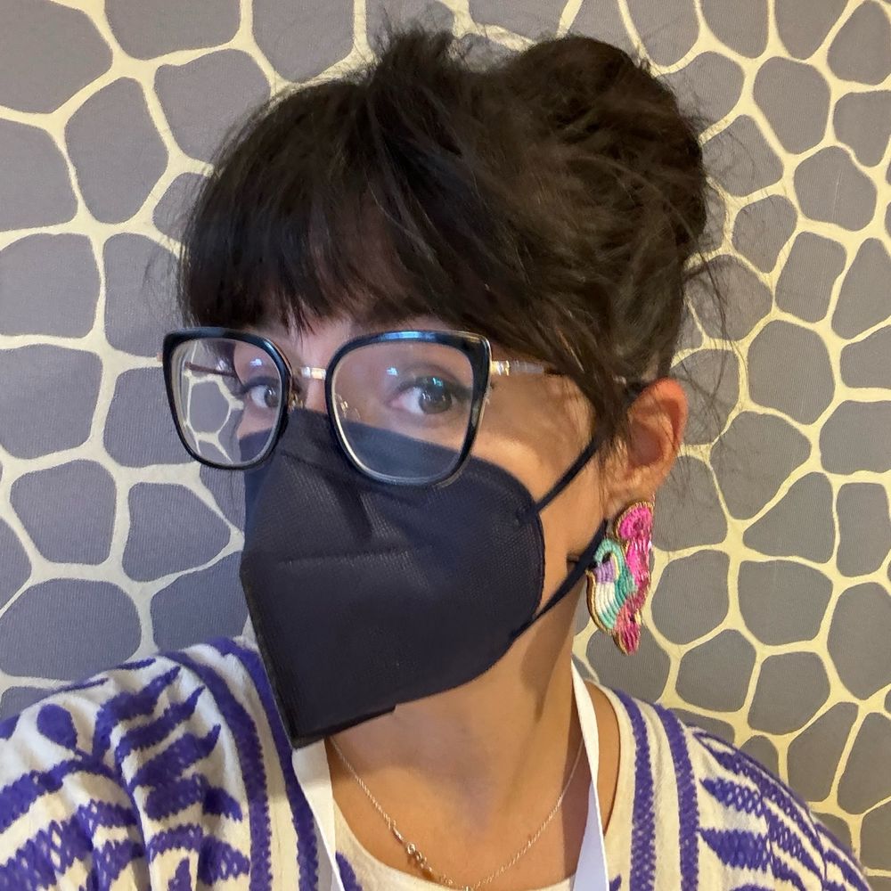 Latina librarian in a KN95 mask taking a bathroom selfie