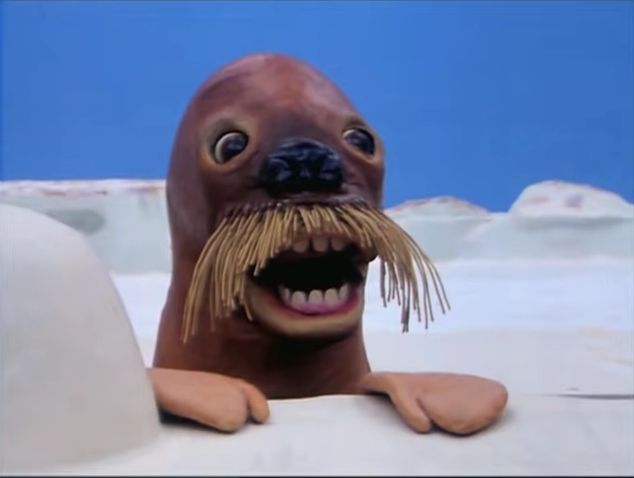 Fuck ass scary walrus thing from pingu with weird human teeth and gross eyes in a snowy scene with blue skies 