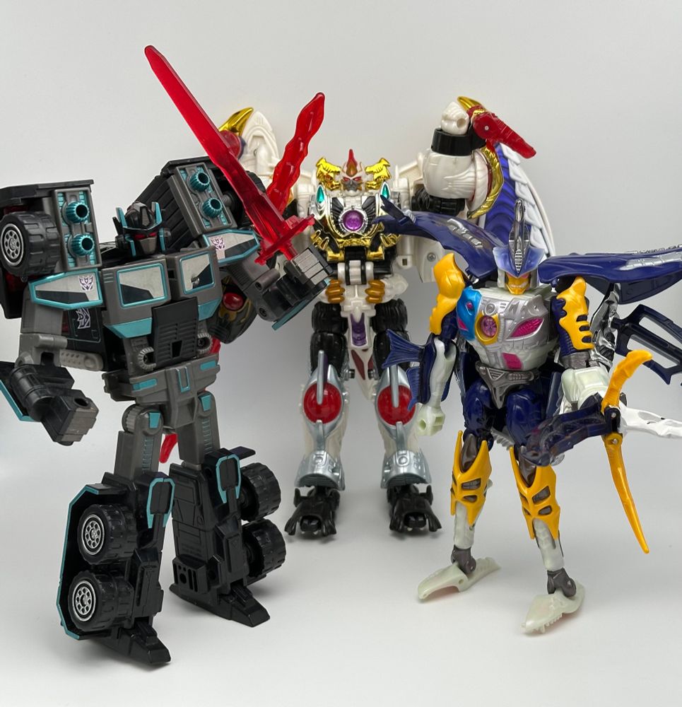 scourge and sky-byte posed with galvatron (an ornate white robot with chromed gold accents)