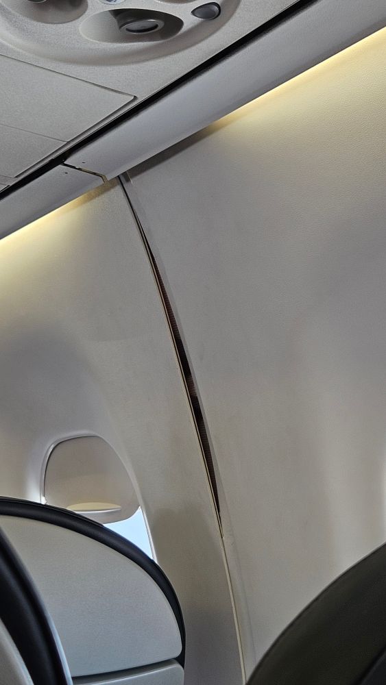 A gap in the interior siding of the airplane.