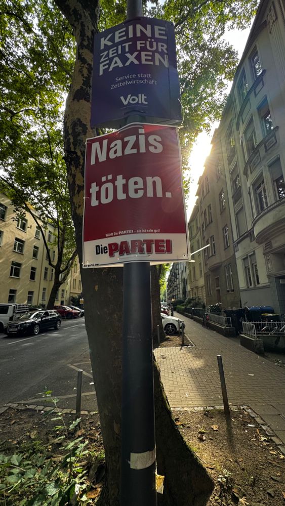 A red and white paper sign from Die Partei, a German political party, with the words “Nazis Töten” (“Kill Nazis”) in large type. 