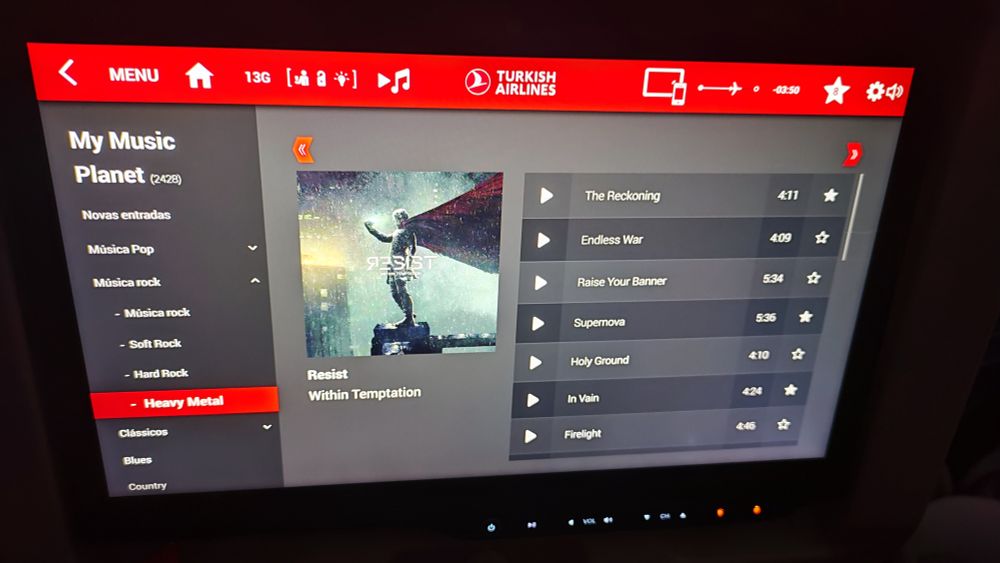 foto da tela do painel do avião da turkish airlines, um tocador de música com o álbum resist, da banda within temptation