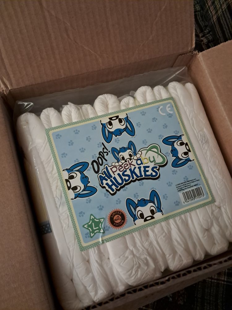 A cardboard box containing a package of Oops! All PeekABU Huskies