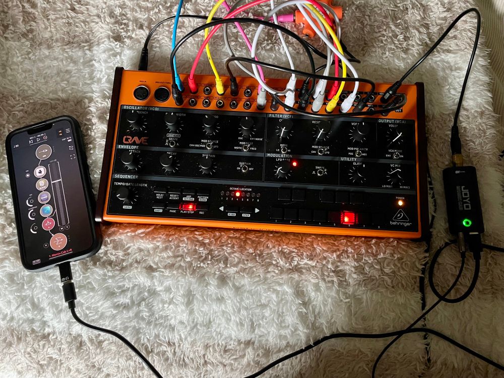 A photo of a Behringer Crave Synthesizer that has been patched to produce semi-random sounds connected to an iPhone using a Joyo MoMix cab interface