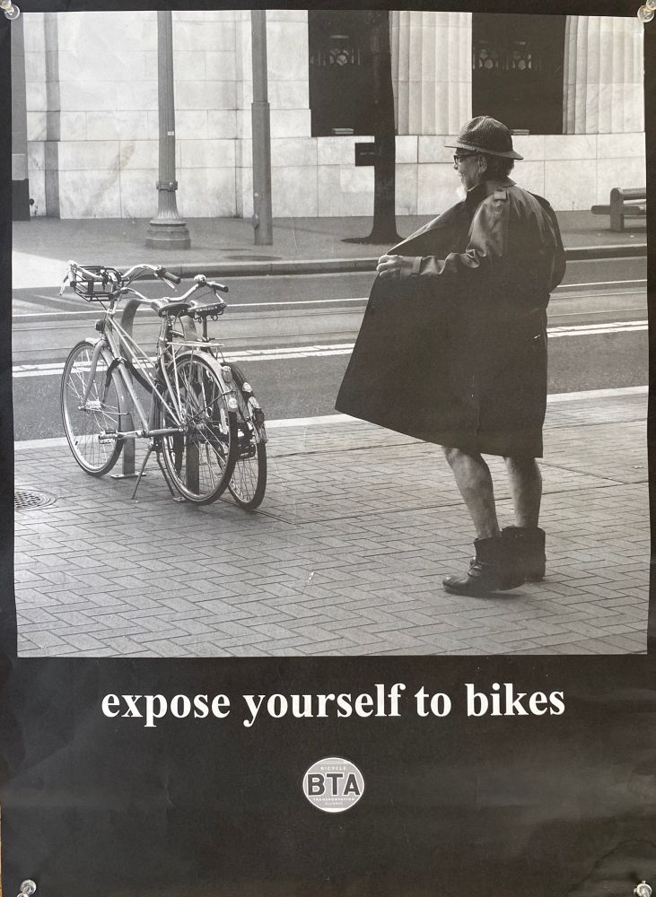 A picture of a person in a trench coat opening it while facing a pair of bikes