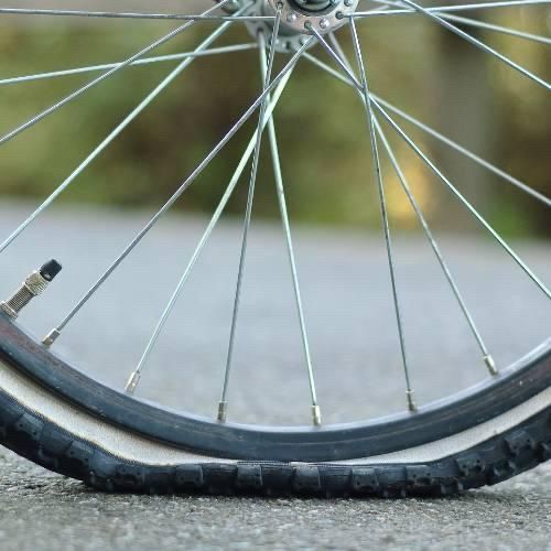 Picture of a bike wheel with a flat tire. This post is about the political landscape in America with our closed government due to a disagreement about how to pay for basic services like healthcare.
