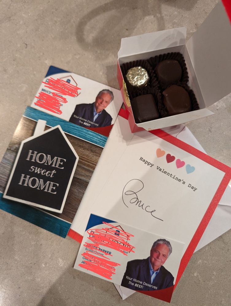 valentine's day card signed BRUCE with a realtor business card, fridge magnet, and box of chocolates