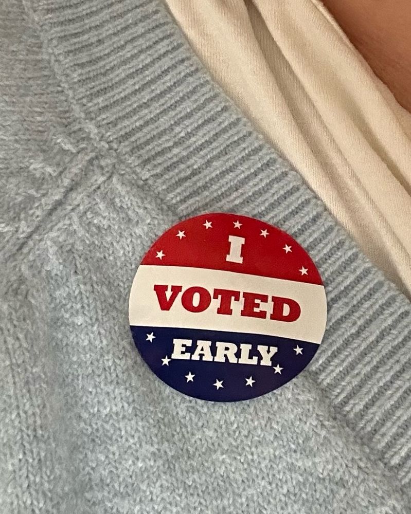 A red, white, and blue sticker that says I VOTED EARLY