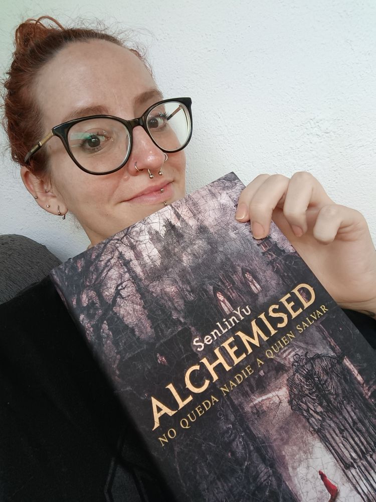 Persona llorosa sostiene el libro Alchemised de SenLinYu. 