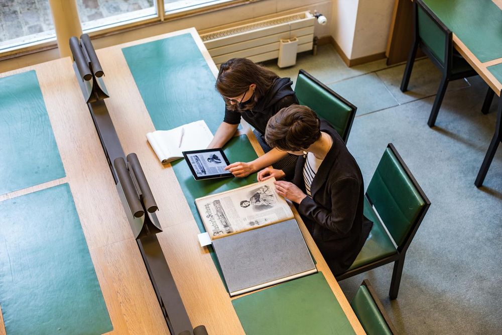 Zwei Personen arbeiten zusammen in der Bibliothek des DHIP