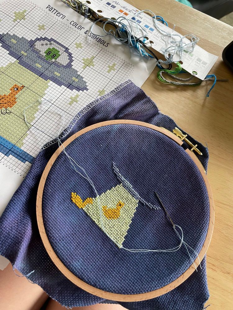 Cross stitch of duck being abducted by alien spaceship 