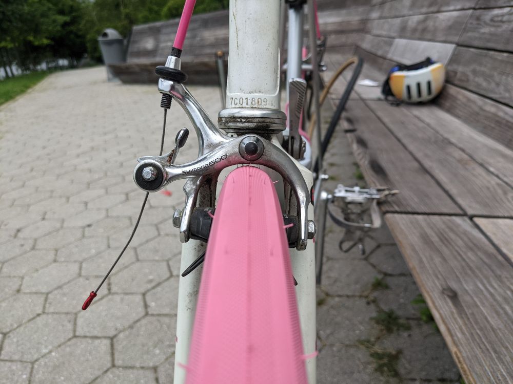 A close-up front view of a bicycle, showing approximately one millimeter of clearance between the front tire and the underside of the brake caliper