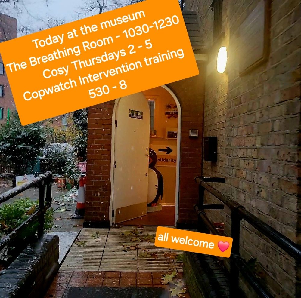 A pic of the museum door with pingu peeping out of a warm cosy looking porch 