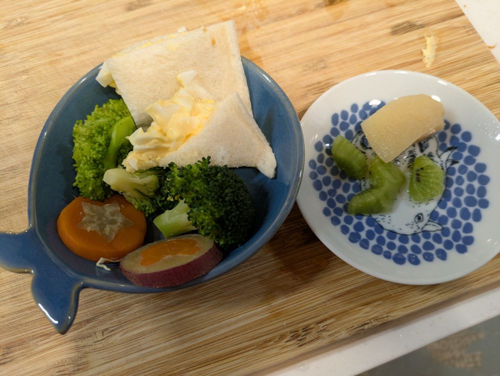 サンドイッチの切れ端や型抜き人参＆さつまいもの残りなど、娘のお弁当のおかずの余りが皿に漫然と盛り付けられている