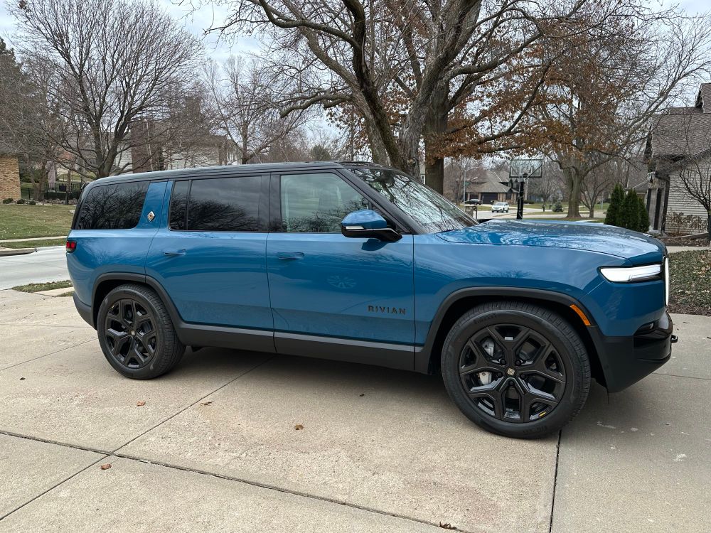A blue Rivian R1S SUV with black trim and wheels.