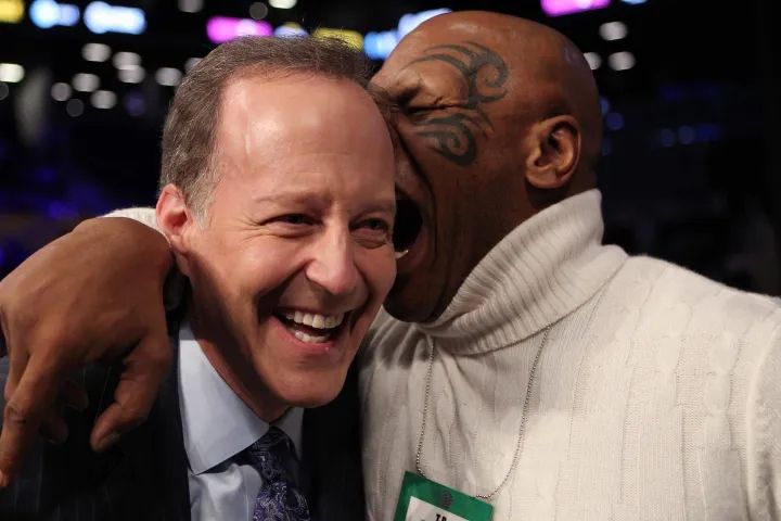 Photograph of sports reporter Jim Gray with Mike Tyson playfully biting his ear