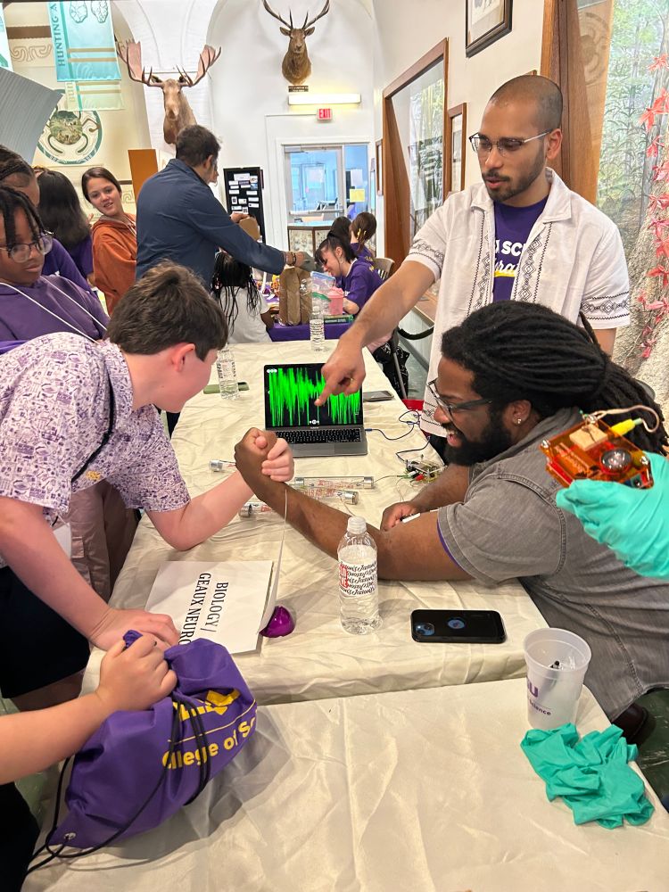Lattin Lab PhD student Marquise Henry uses arm wrestling to show nerve impulses in an active muscle via electromyography 
