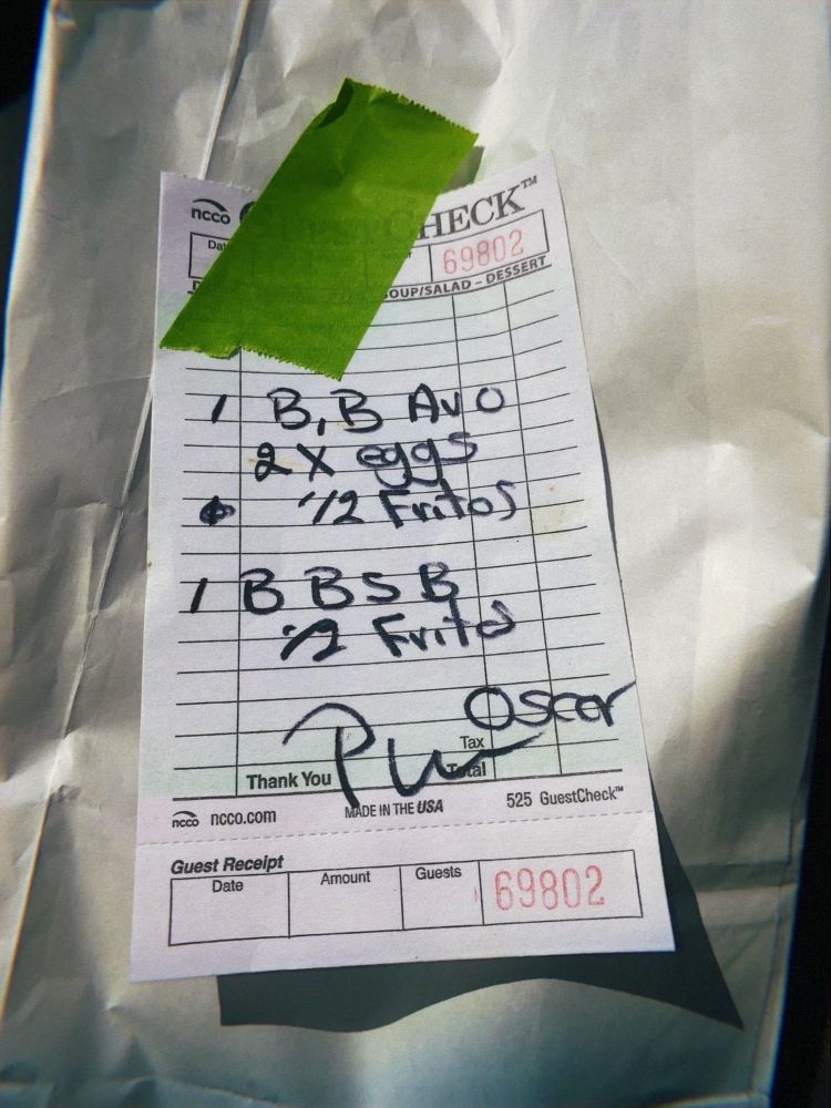 A paper guest check receipt for breakfast burritos. 